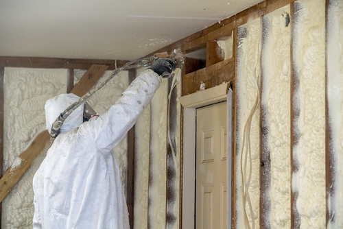 Worker Spraying Spray Foam Insulation In A Home