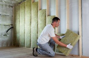 Person installing insulation in residential basement